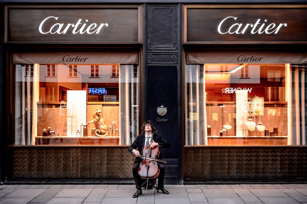 Cartier as a brand for watches man playing cello in front of store